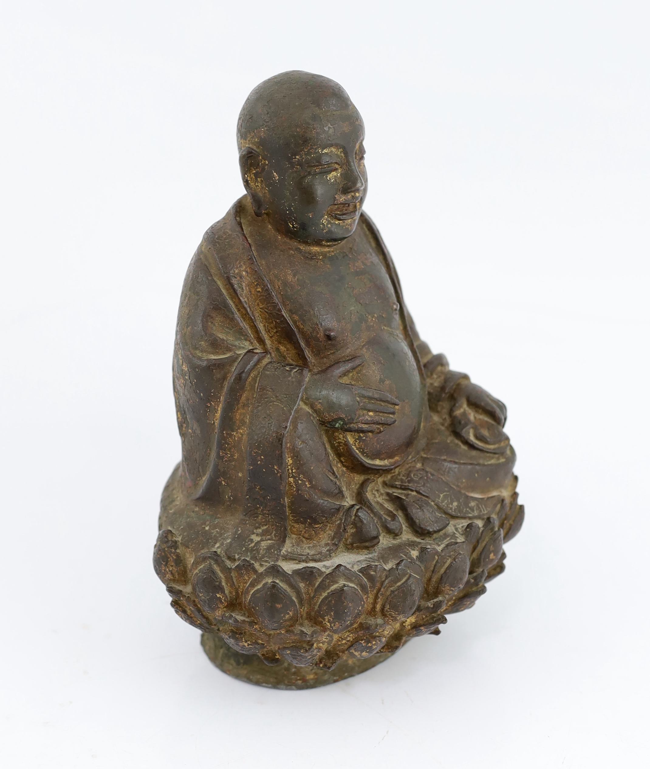 A Chinese lacquered bronze figure of Budai, late Ming dynasty, cracks and old repairs